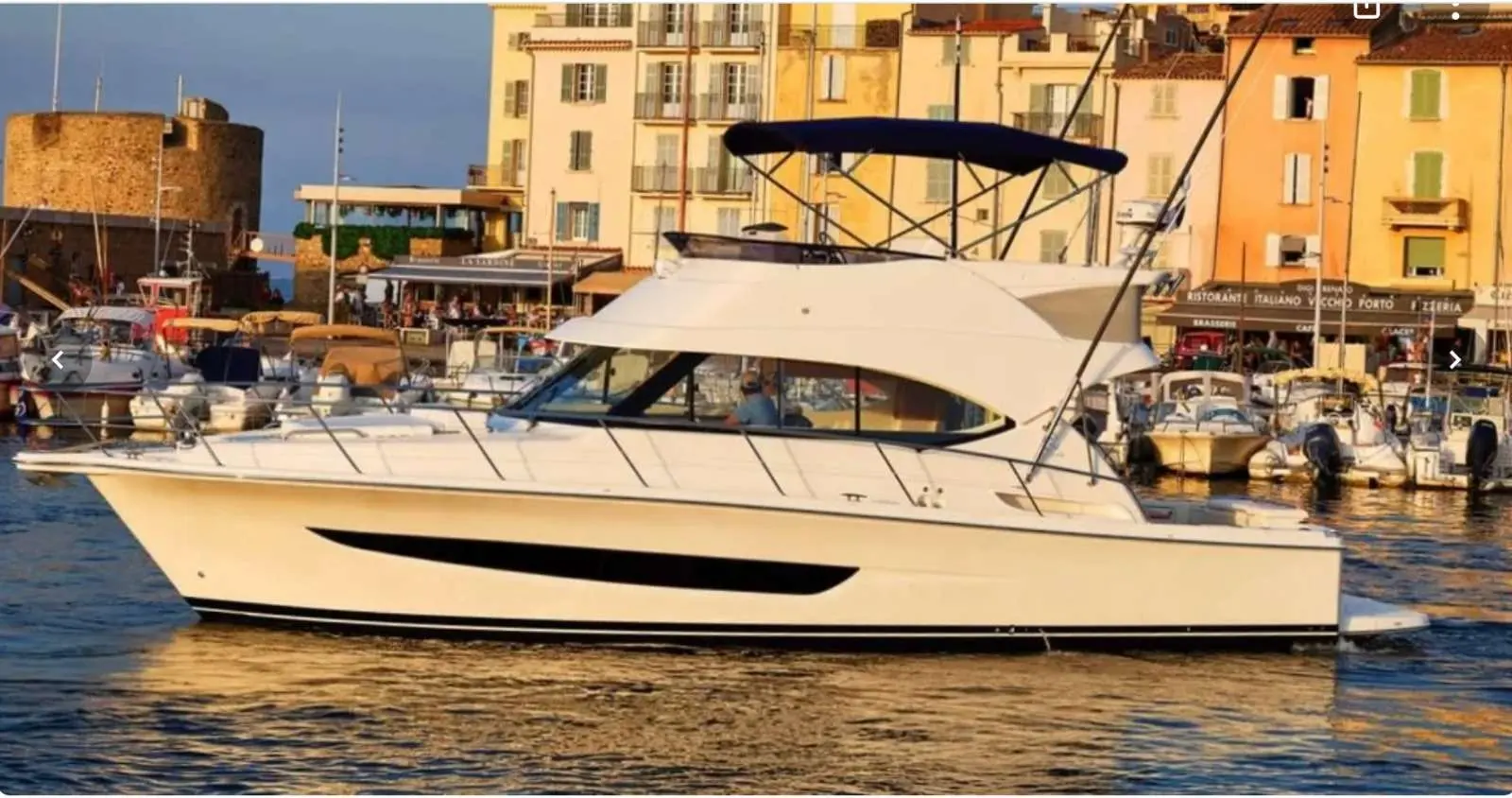 Riviera 39 — Vue latérale d’un bateau à moteur amarré dans un port méditerranéen.