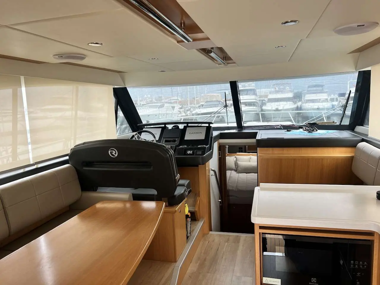 Riviera 39 — Vue intérieure du salon et du poste de pilotage, avec vue sur la marina.