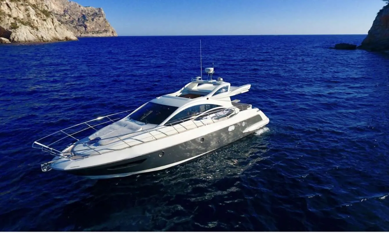 Azimut 43 — Bateau à moteur blanc photographié au large, entre des falaises.