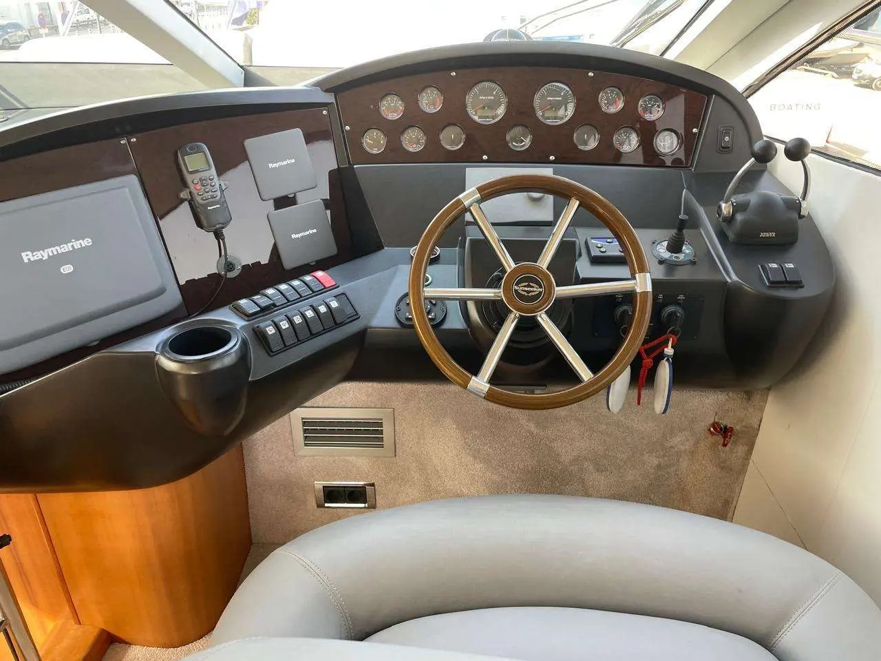 Sunseeker Manhattan 50 — Poste de pilotage intérieur avec volant en bois, instruments analogiques et écrans de navigation.