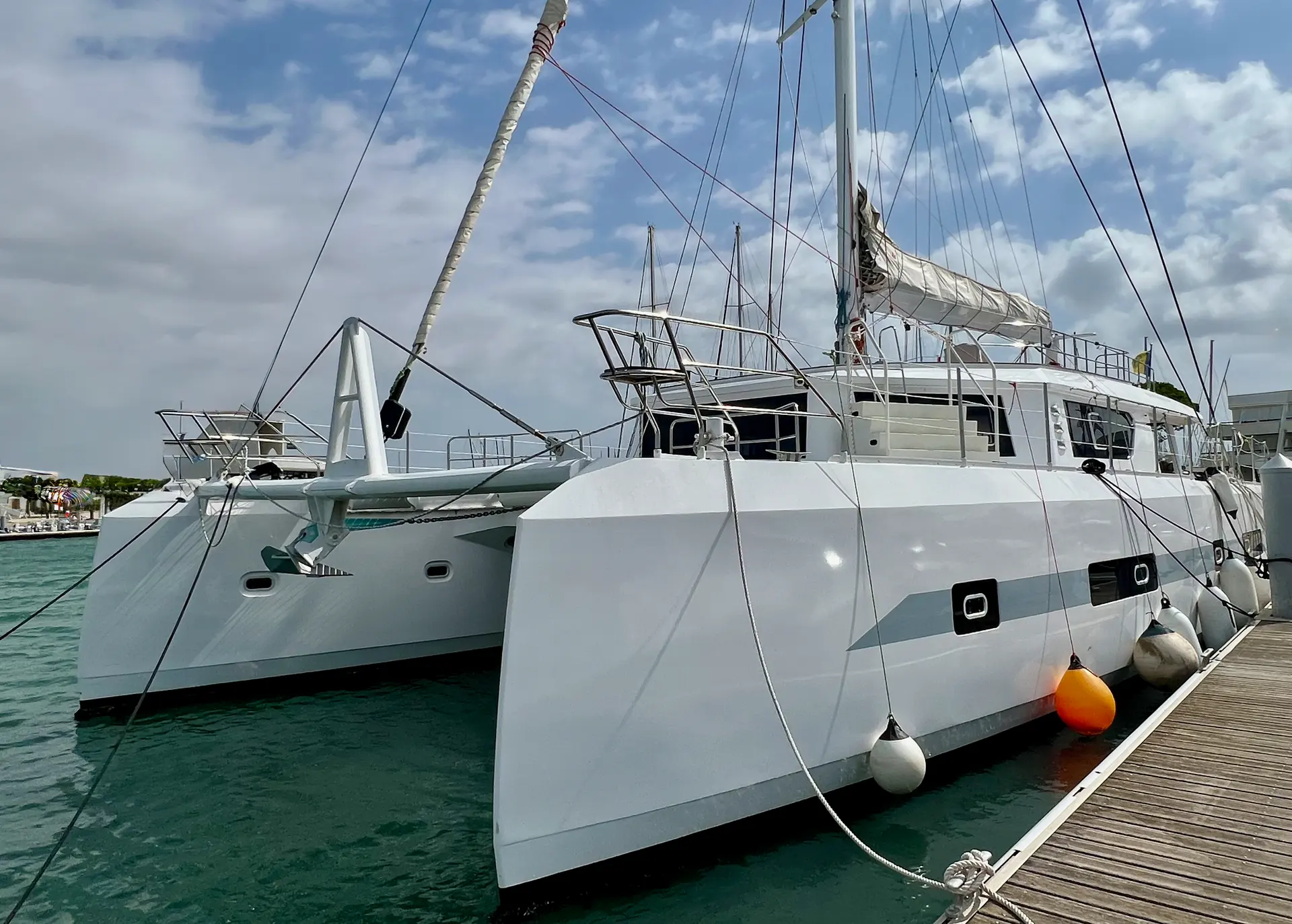 Squalt Marine International CK70 — Catamaran blanc amarré à un ponton, vu de trois quarts dans une marina.
