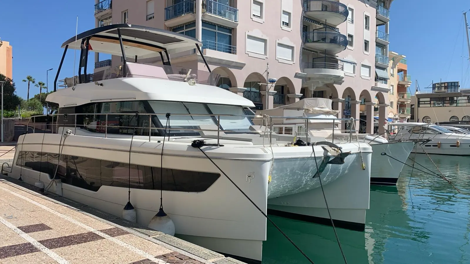 Fountaine Pajot My 40 — Catamaran à moteur amarré dans une marina, vu de trois quarts avant.