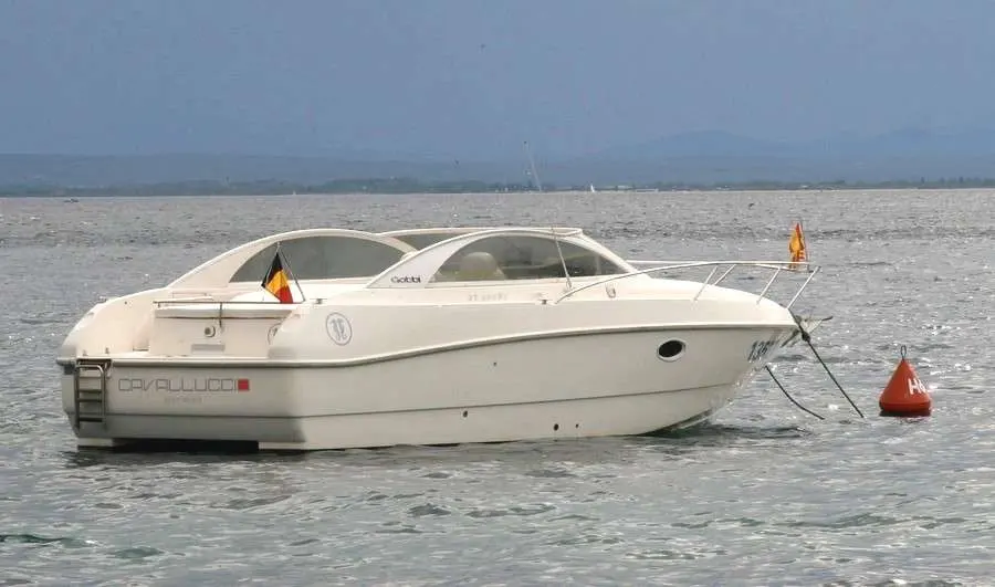 Gobbi 27 Sport — Bateau à moteur blanc amarré sur une bouée, vu de profil sur une mer agitée.