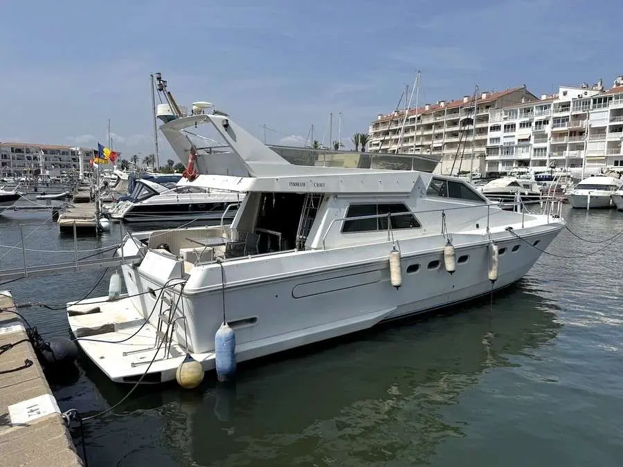 Ferretti Altura 52 — Bateau à moteur blanc amarré dans une marina, vu de trois quarts arrière.