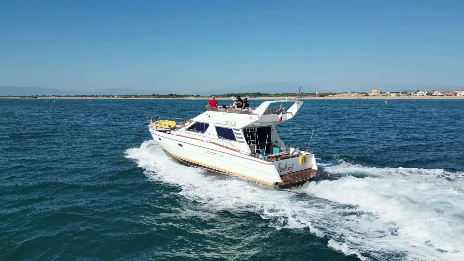 Vitech 59 — Bateau à moteur blanc vu de trois quarts arrière, naviguant au large.