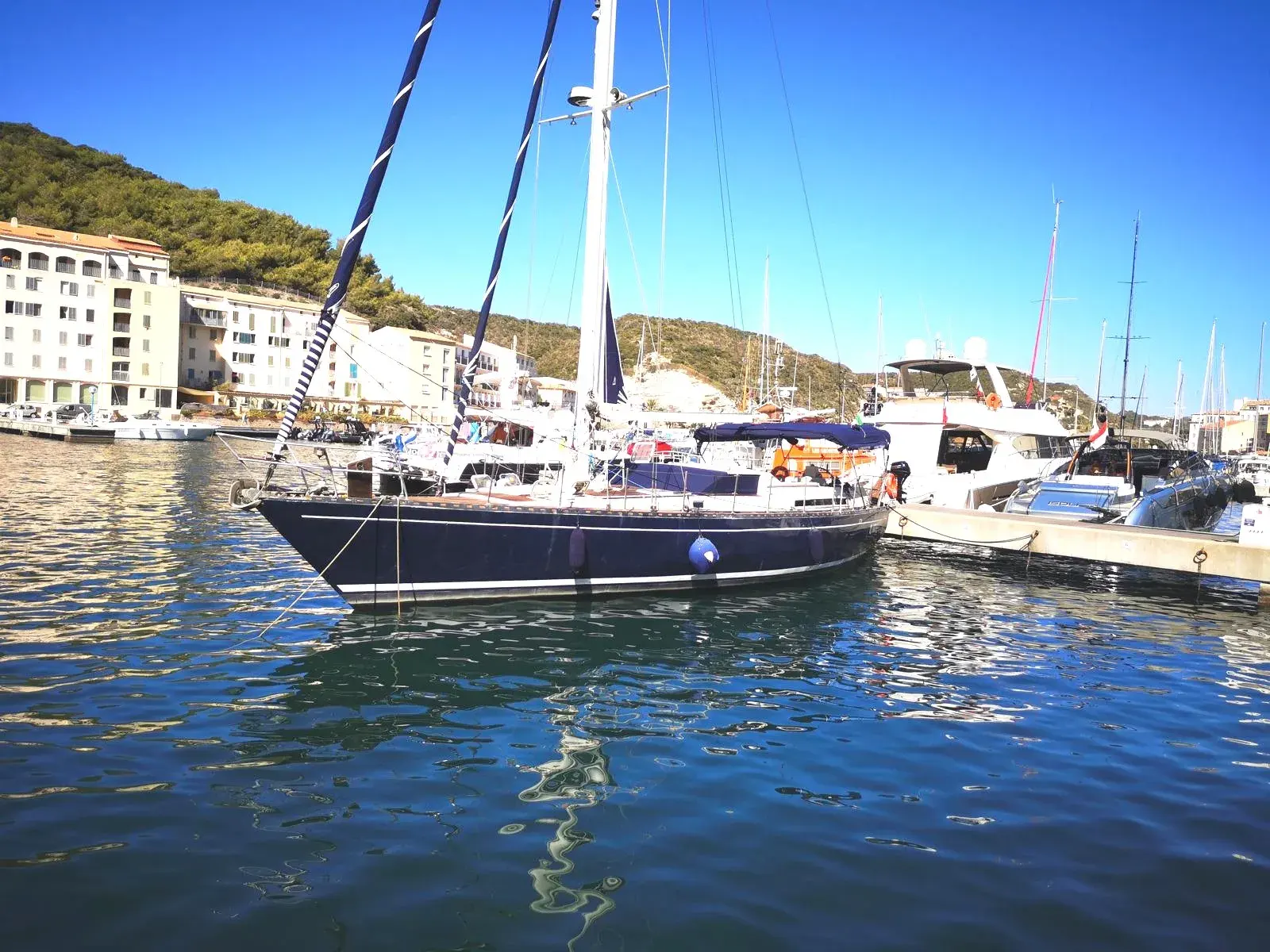 Ferretti 53 — Voilier amarré dans un port, photographié de profil par temps ensoleillé.