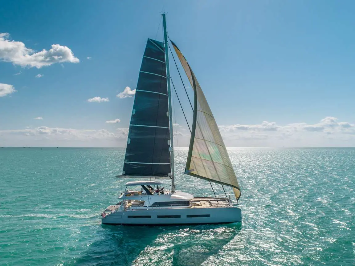 Lagoon Seventy 7 — Catamaran à voiles naviguant sur une mer turquoise sous un ciel dégagé.
