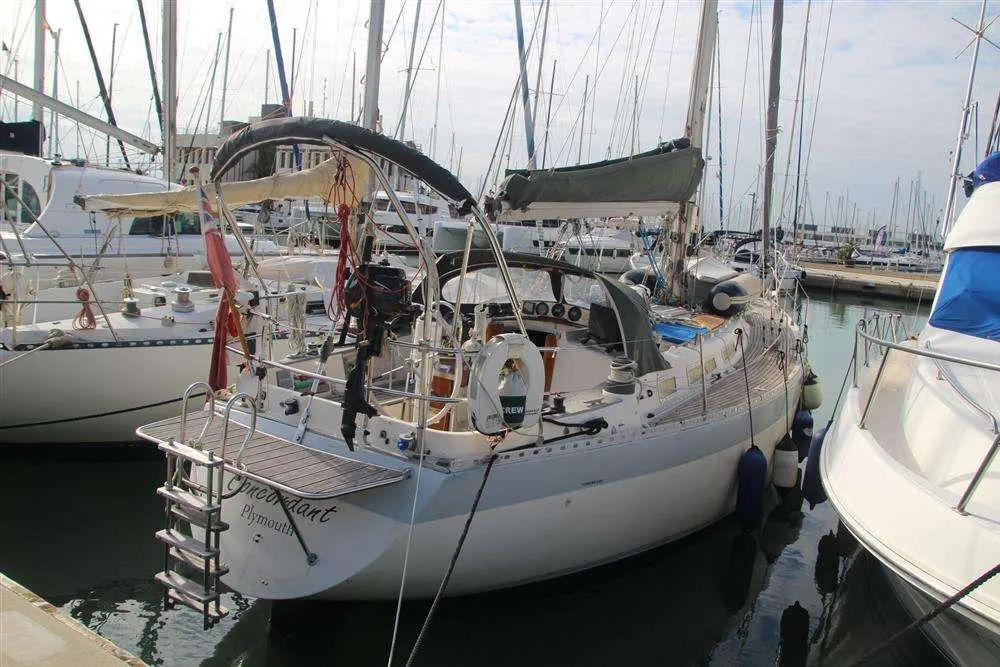 Wauquiez Hood 38 — Voilier blanc amarré dans une marina, photographié de trois quarts arrière.