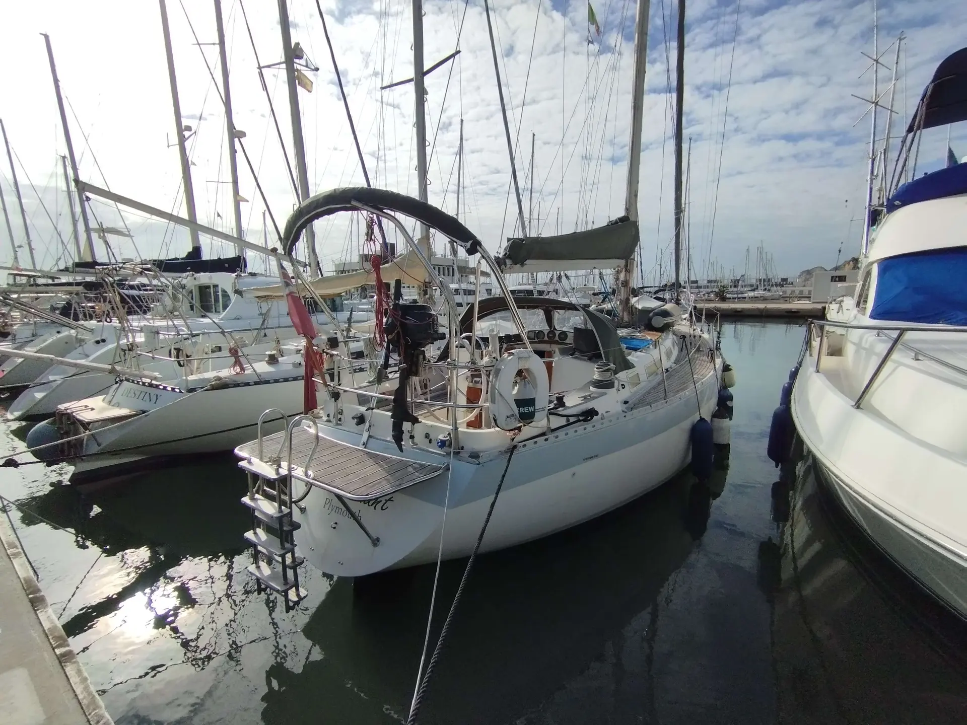 Wauquiez Hood 38 — Voilier blanc amarré dans un port, vu de trois quarts arrière.