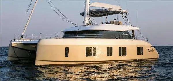 Sunreef Yachts Sunreef 50 — Catamaran vu de trois quarts sur l’eau, avec ses voiles et son pont supérieur.