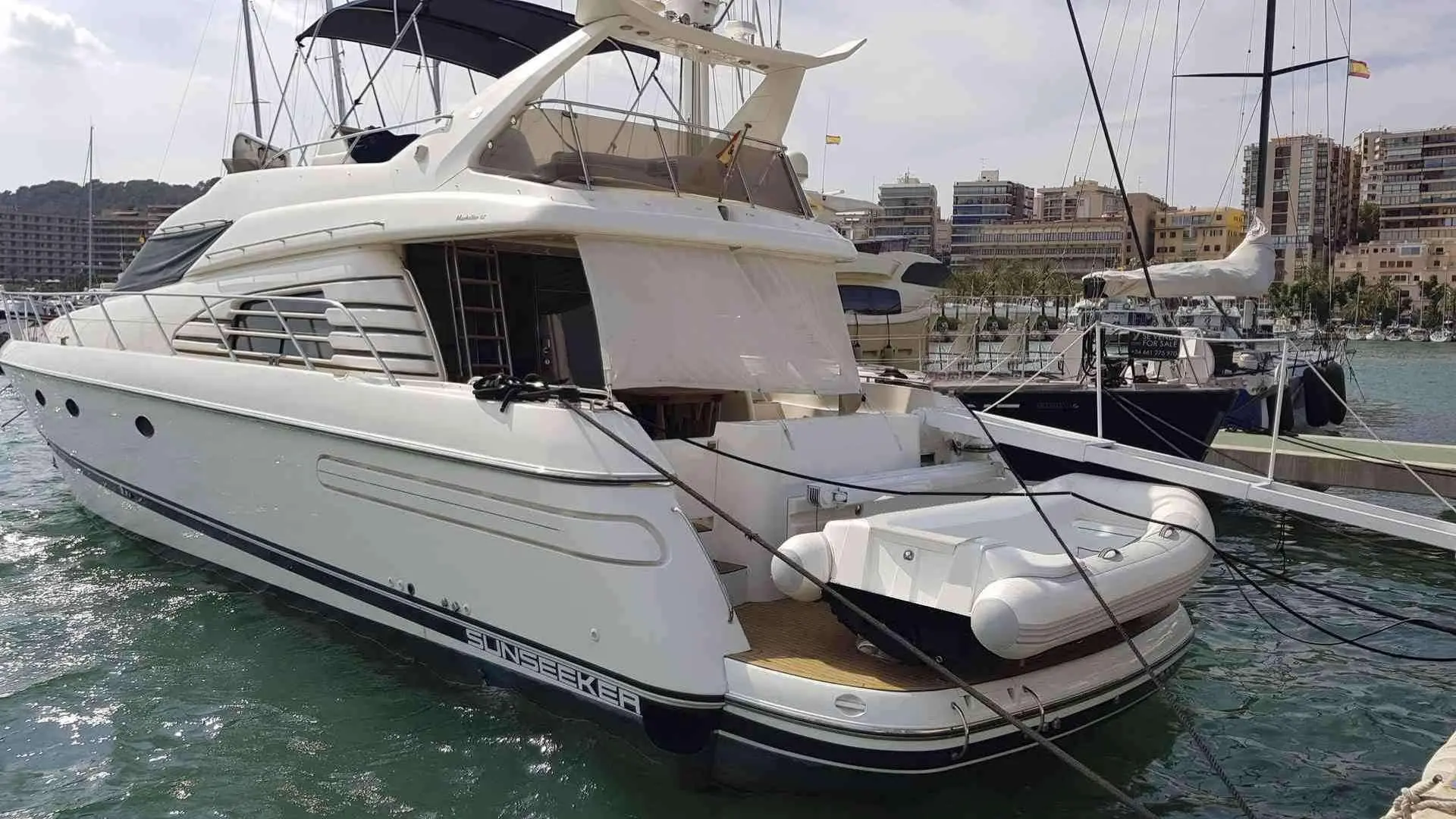 Sunseeker Manhattan 62 — Bateau à moteur blanc amarré dans un port, vu depuis l’arrière tribord.