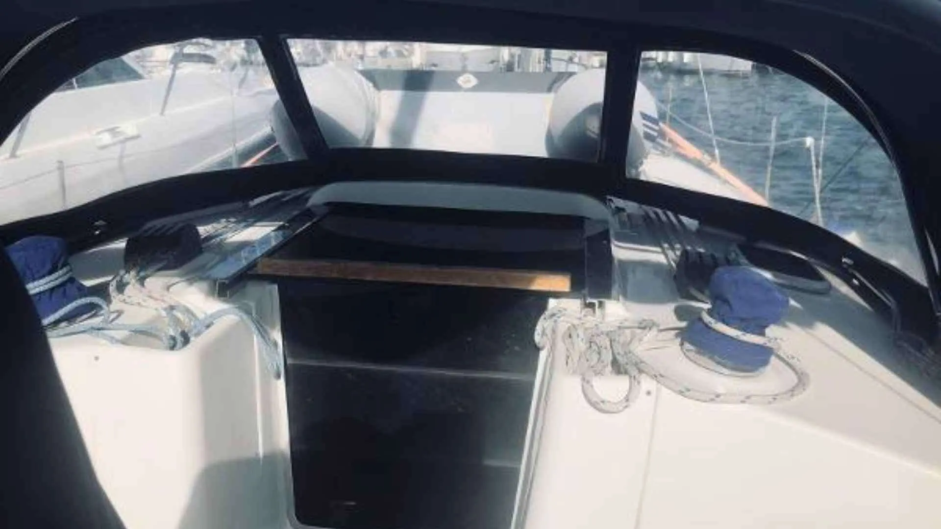 Hunter 38 — Vue du cockpit d’un voilier sous sa capote, avec winchs et cordages visibles.