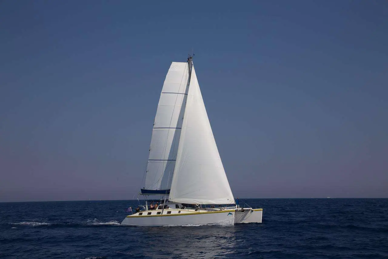 Custom Catamaran — Catamaran à voiles naviguant en mer par temps dégagé.