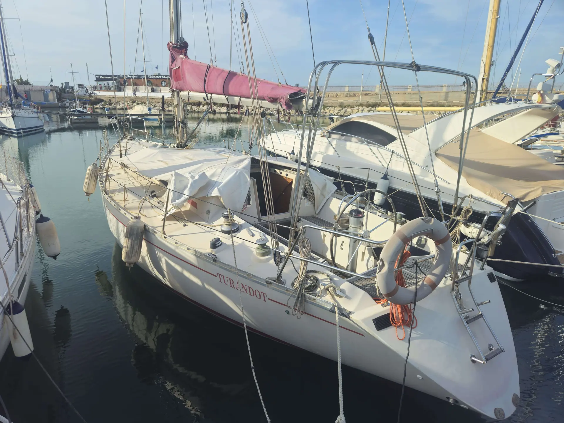 Beneteau First 42 — Voilier blanc amarré dans un port, photographié en vue trois quarts avant.