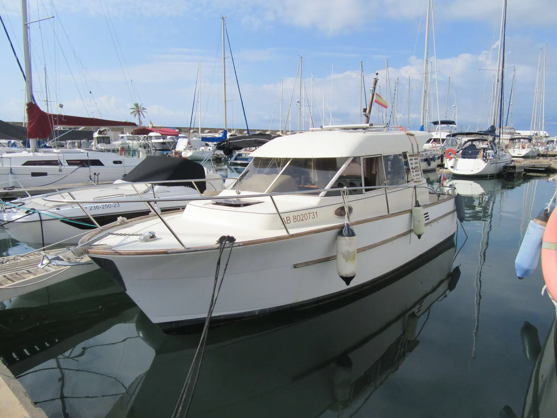 ACM Heritage 26 — Vedette blanche amarrée dans une marina, entourée d'autres bateaux.