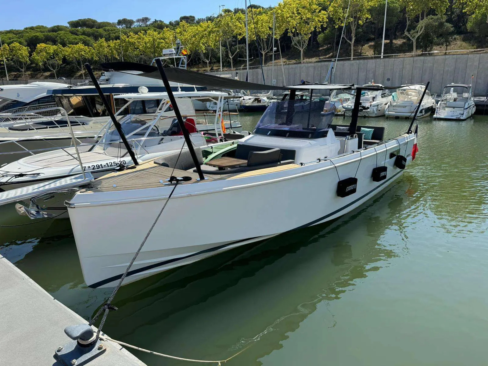 Fjord 36 Xpress — Vue trois-quarts d’un bateau blanc amarré dans une marina, sans personnes visibles.