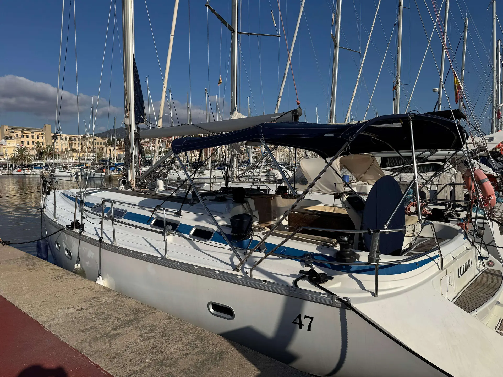 Bavaria 47 — Voilier amarré dans un port, photographié de trois quarts.