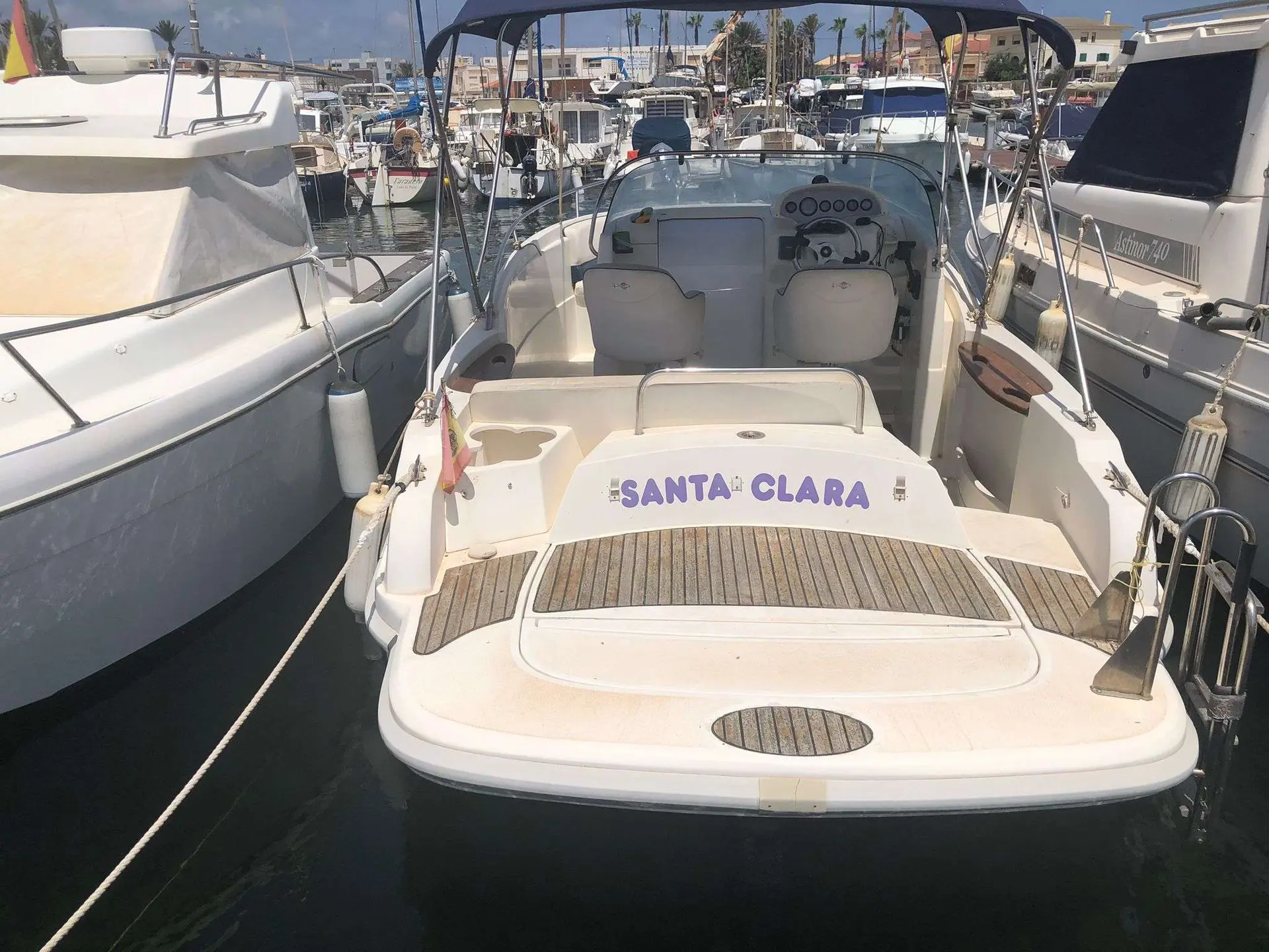 Rio 750 Sol — Vue arrière d’un bateau amarré, avec cockpit, banquette et poste de pilotage visibles.