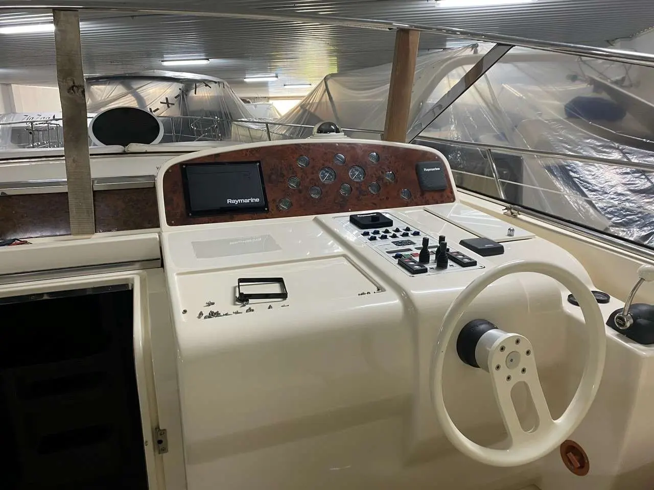 Ilver 39 Mirable — Poste de pilotage intérieur avec écran Raymarine, commandes et volant.