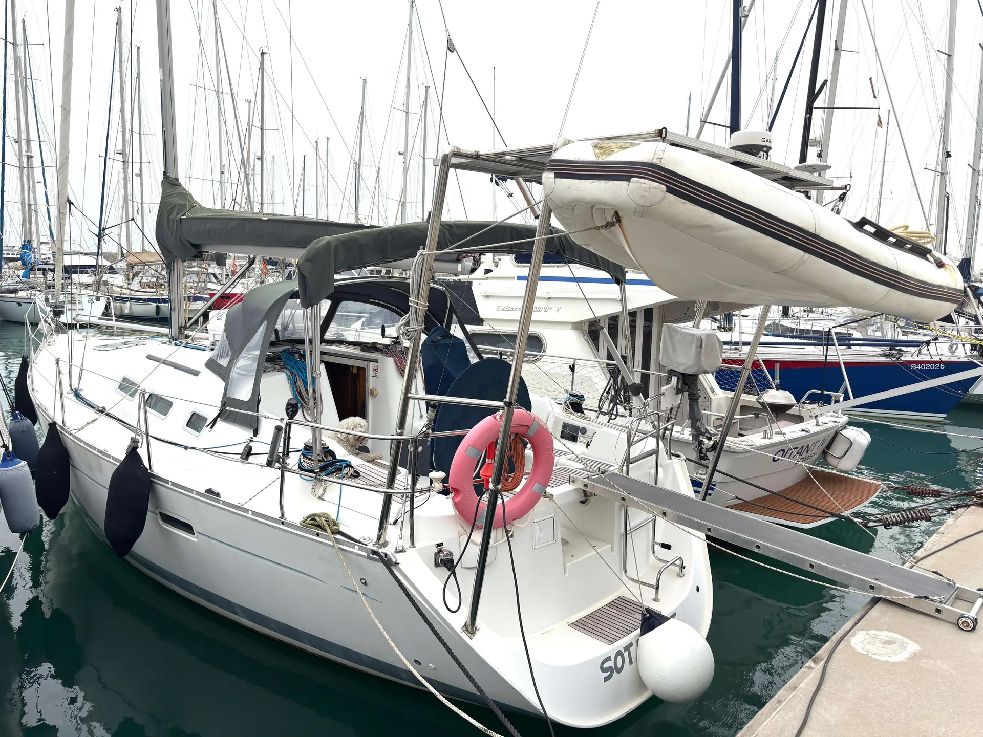 Beneteau Oceanis 373 — Voilier blanc amarré dans une marina, avec une annexe suspendue à l’arrière.