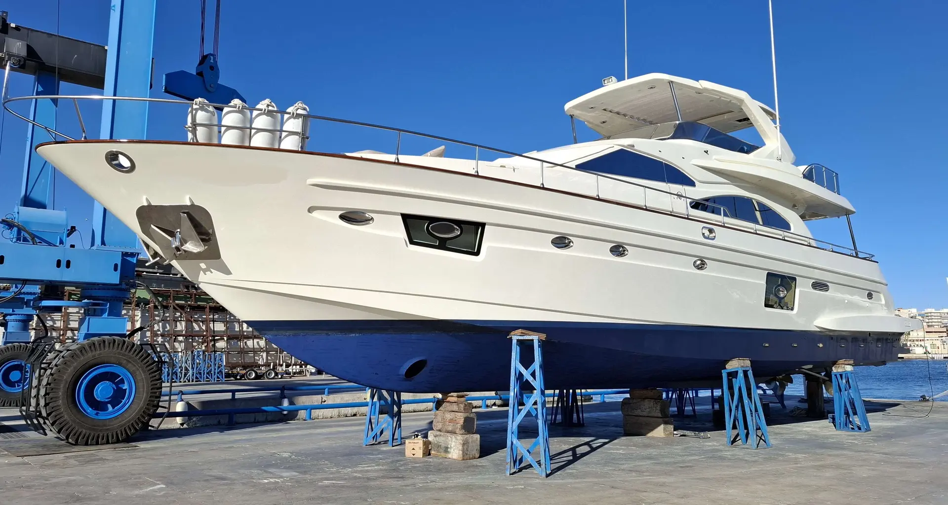 Astondoa 72 GLX — Vue latérale d’un yacht à moteur blanc sur bers dans un chantier naval.