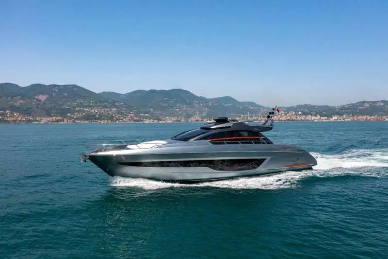 Riva 66 Ribelle — Bateau à moteur gris naviguant devant une côte montagneuse