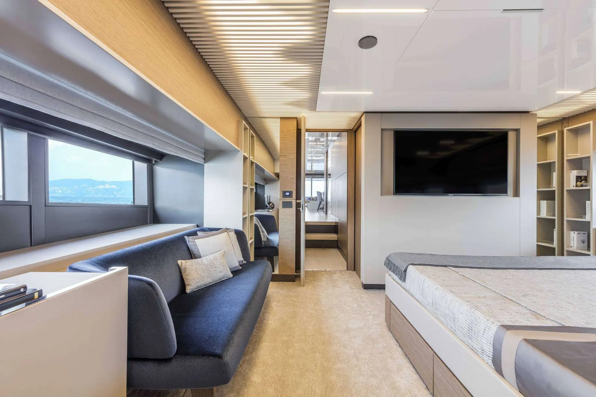 Ferretti 920 — Cabine avec lit, canapé, rangements et télévision à écran plat.