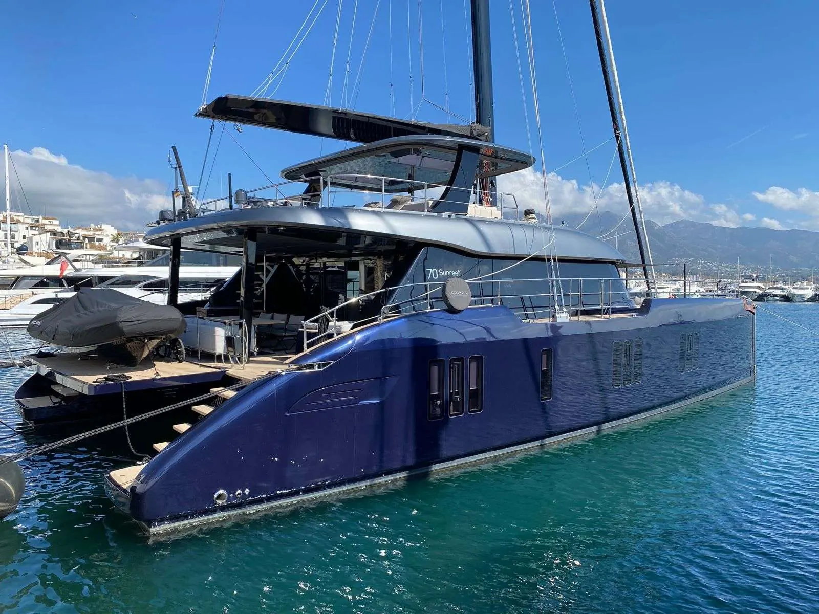 Sunreef Yachts Sunreef 70 — Catamaran à voile bleu amarré dans une marina, vu de trois quarts bâbord.