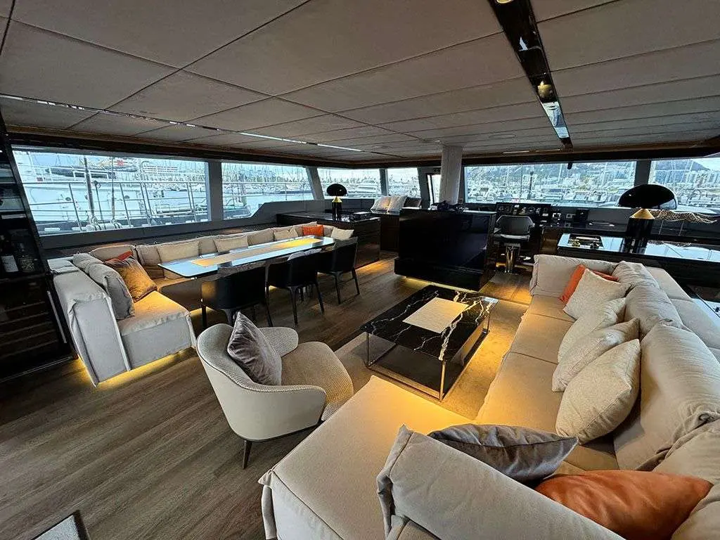 Sunreef Yachts Sunreef 70 — Salon intérieur avec espace repas, assises et poste de pilotage panoramique.