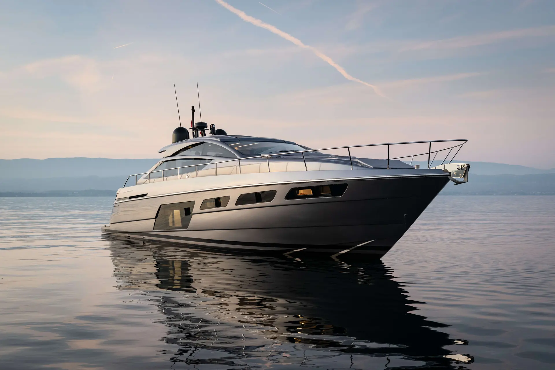 Pershing 6X — Bateau à moteur vu de trois quarts sur une mer calme, au coucher du soleil.