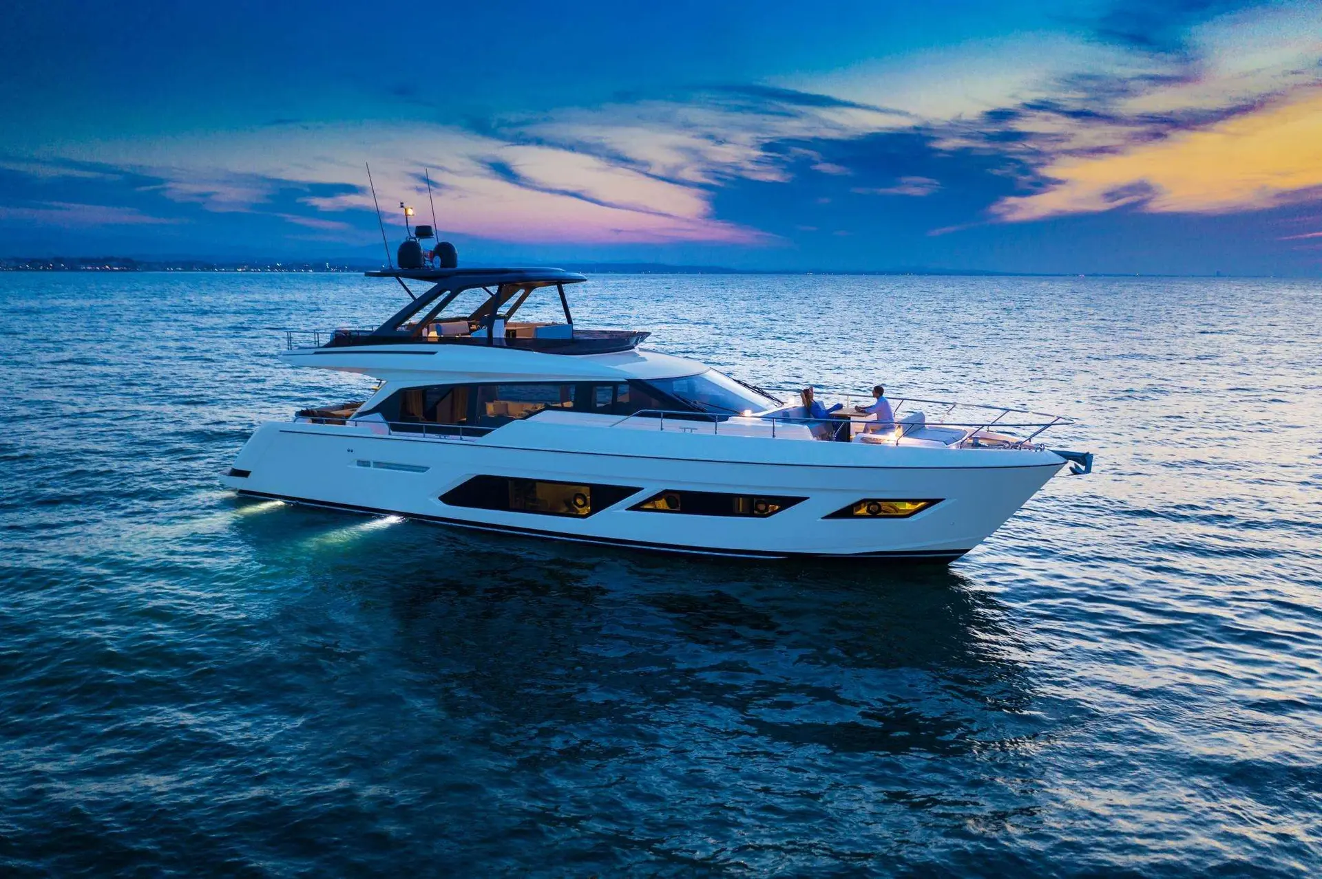 Ferretti 720 — Bateau à moteur blanc vu de trois quarts sur la mer au coucher du soleil.