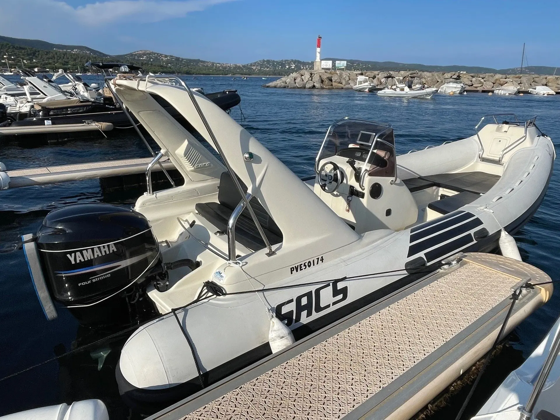 Sacs S 680 Ghost — Bateau pneumatique blanc amarré dans une marina, vu de trois quarts arrière.