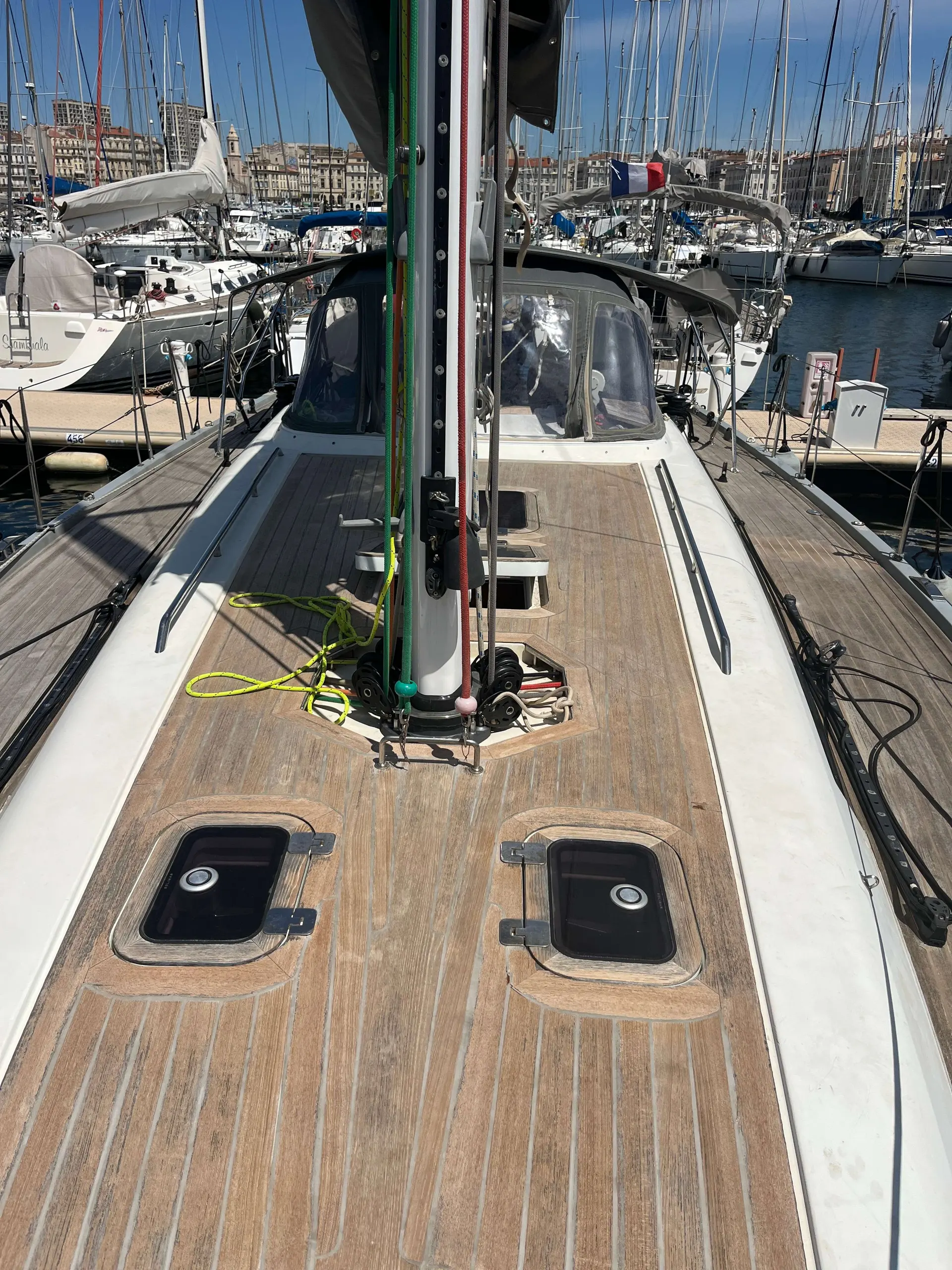 Solaris 42 — Vue du pont avant d'un voilier amarré, avec mât, gréement et bateaux en arrière-plan.