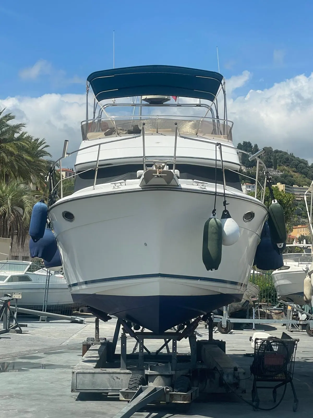 Carver 850 Fly — Vue frontale d’un bateau à moteur sur ber, avec taud et défenses.