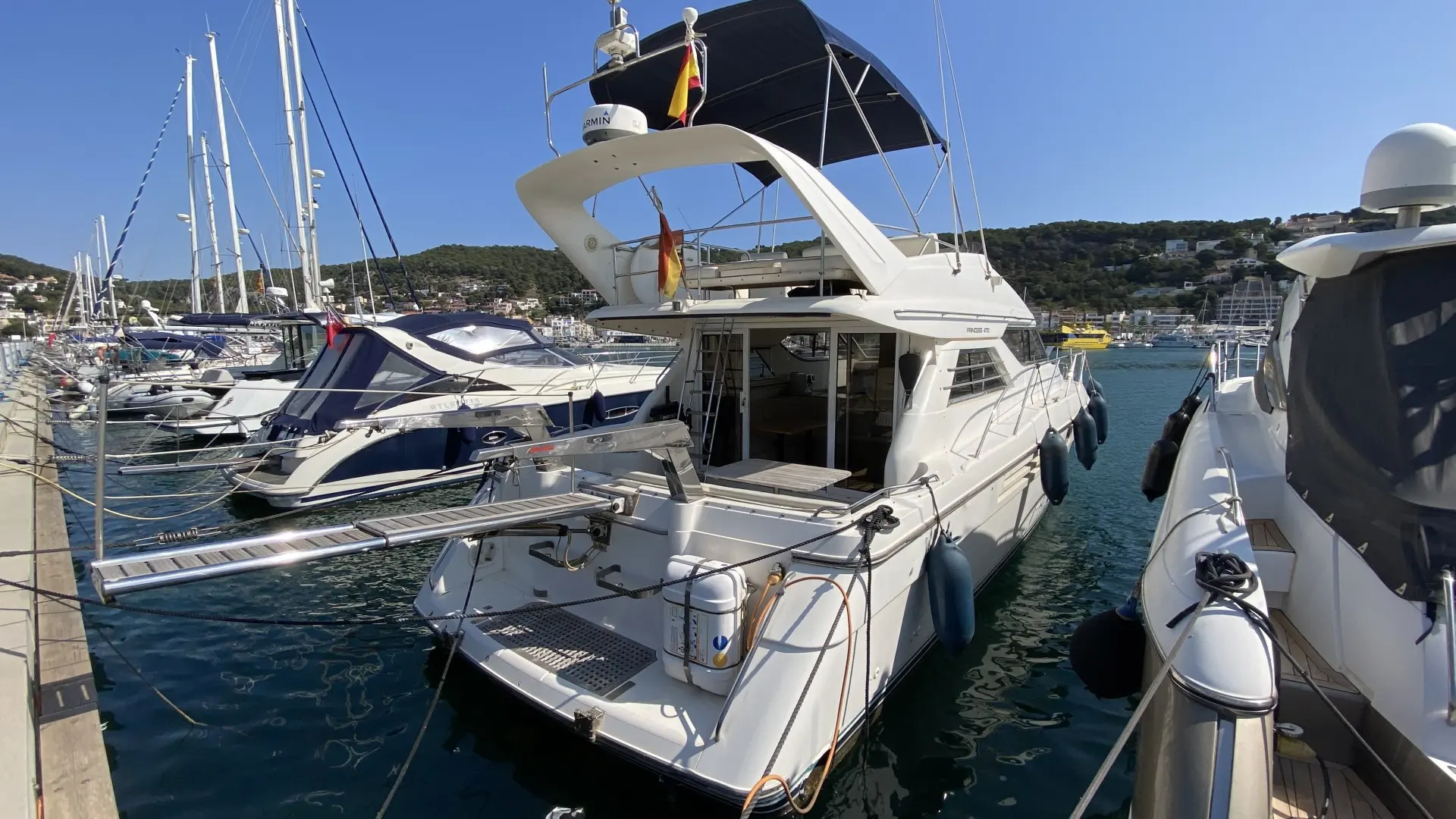 Princess 470 — Bateau à moteur blanc amarré dans une marina, vu de trois quarts arrière.