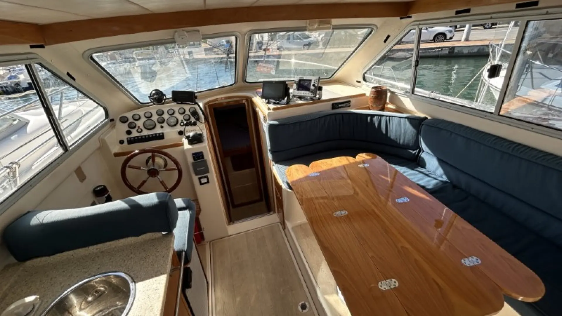 Rodman 970 — Vue intérieure du poste de pilotage et du carré avec table et banquettes.