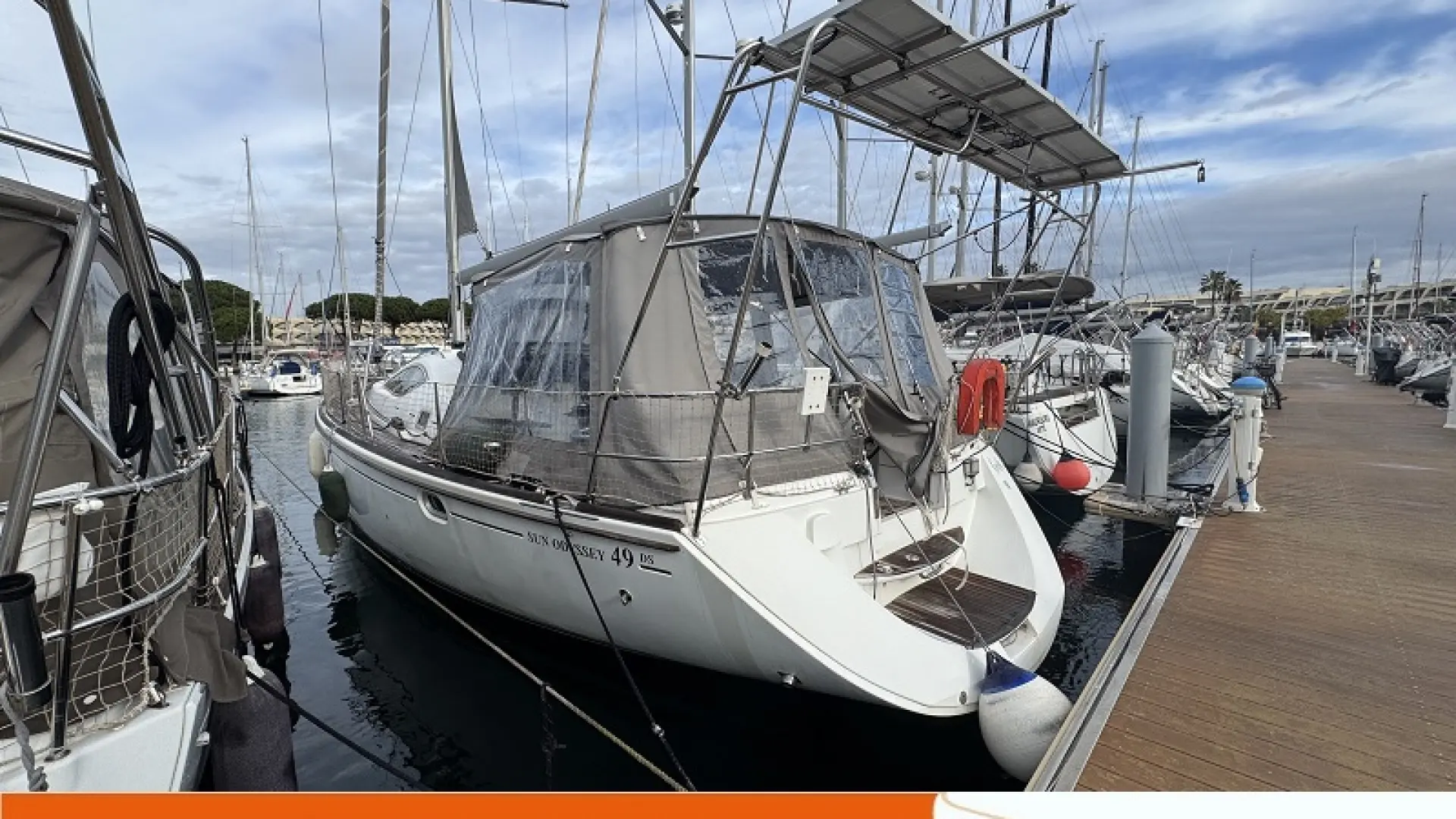 Jeanneau Sun Odyssey 49 DS — Voilier blanc amarré dans une marina, photographié de trois quarts arrière.