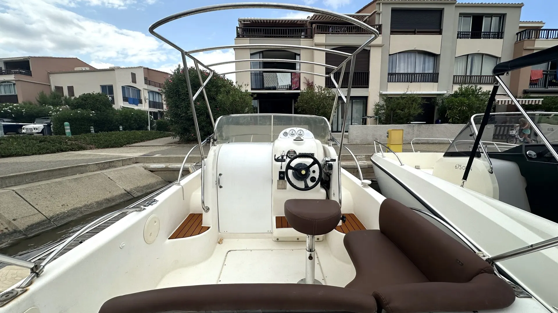 Ultramar Winner 650 — Vue du poste de pilotage et du cockpit d’un bateau à moteur amarré.