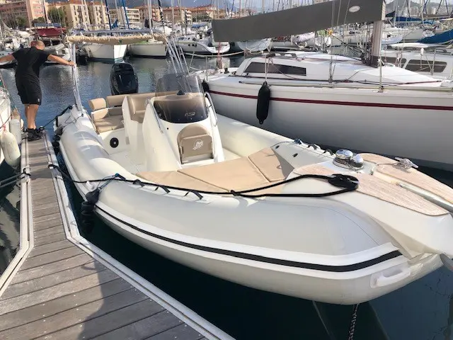 Black Fin Elegance 8 — Bateau semi-rigide blanc amarré dans une marina, vu de trois quarts avant.