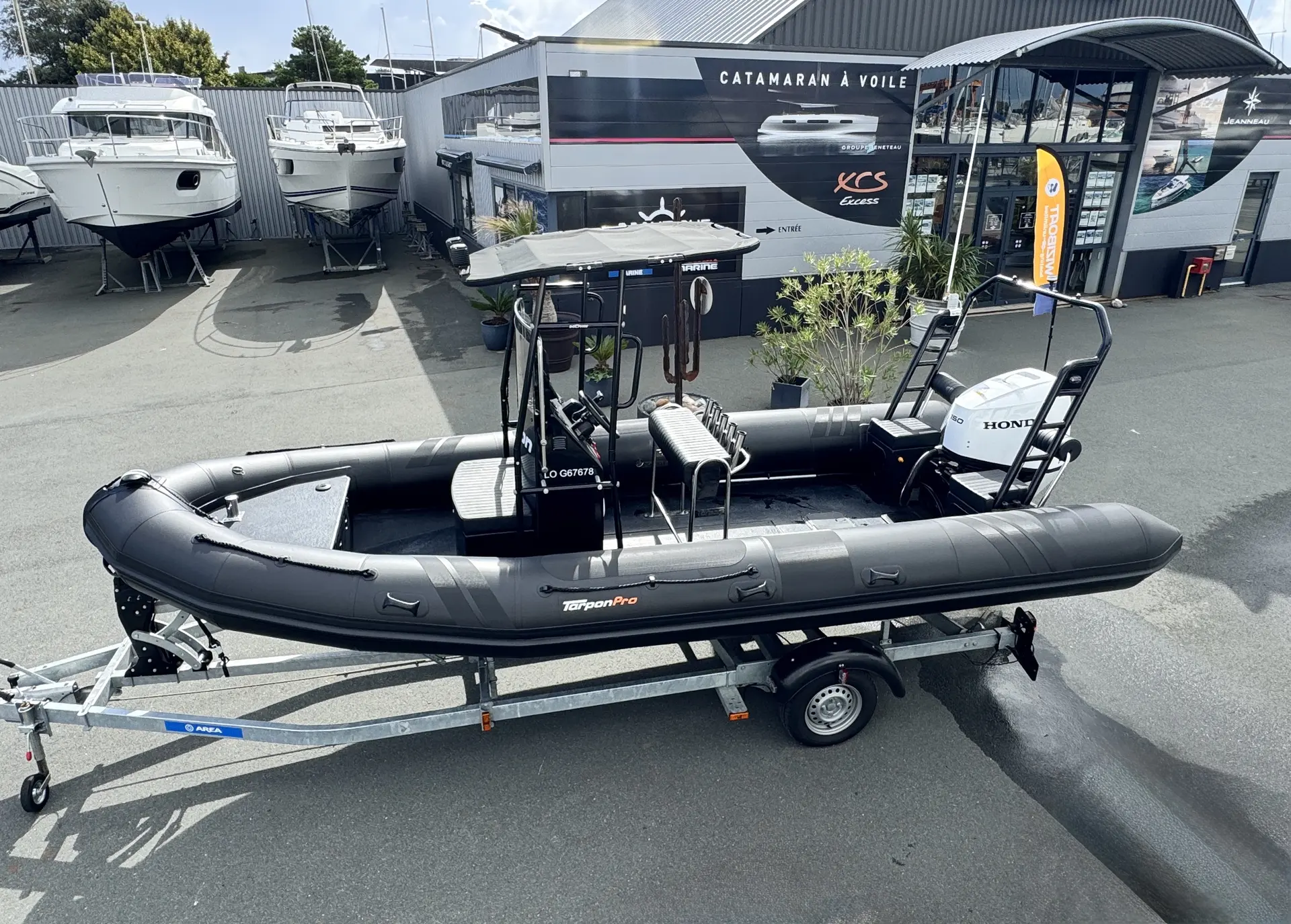 Tarpon DV65 — Semi-rigide noir présenté sur sa remorque devant un concessionnaire nautique.