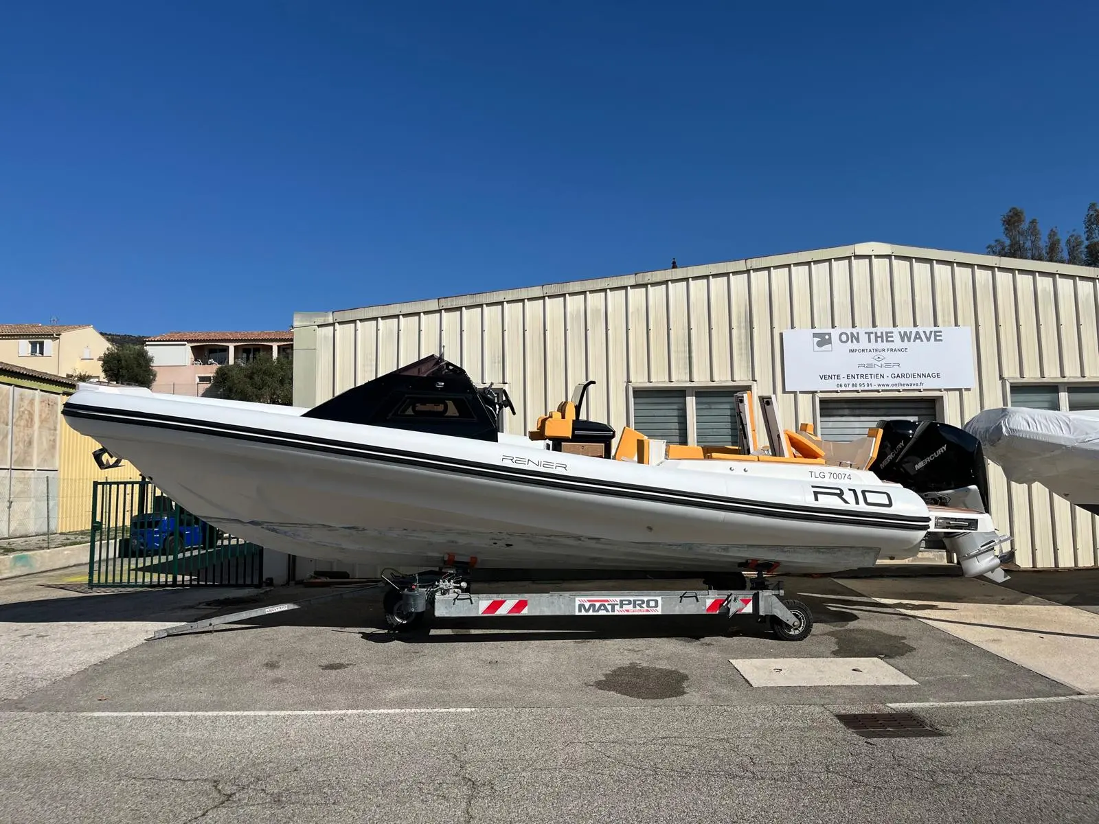 Renier R10 — Bateau pneumatique blanc présenté sur une remorque devant un bâtiment.