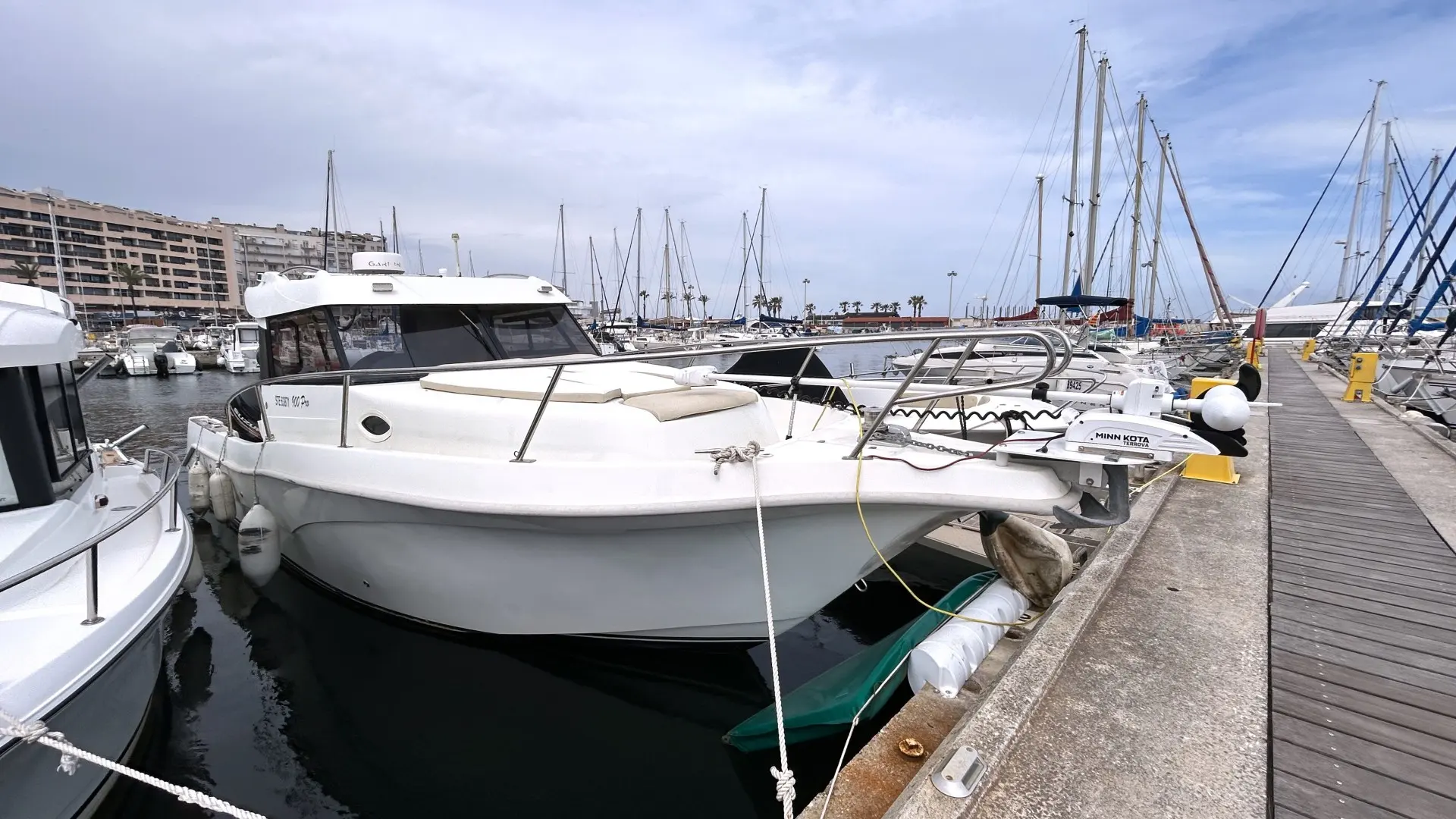 San Remo 900 Pro — Bateau à moteur blanc amarré dans un port de plaisance.