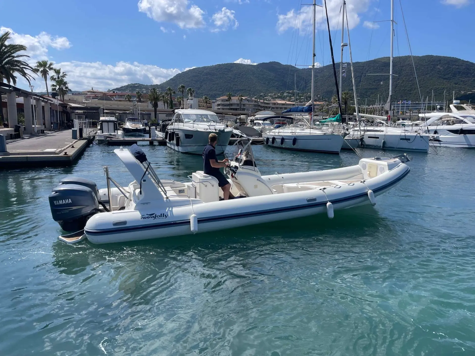 Nuova Jolly King 820 Extreme — Semi-rigide blanc photographié de profil dans une marina avec une personne à bord.