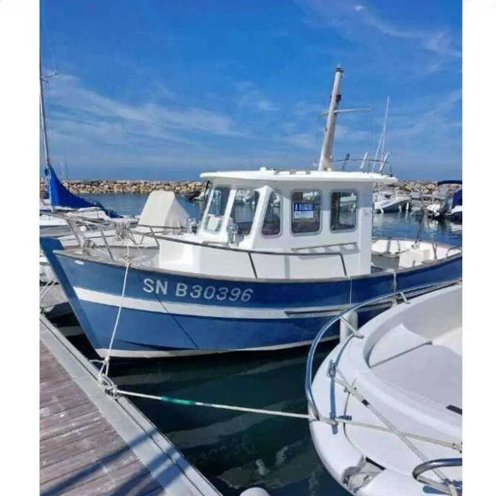 Rhea 650 — Bateau de pêche bleu et blanc amarré dans un port de plaisance.