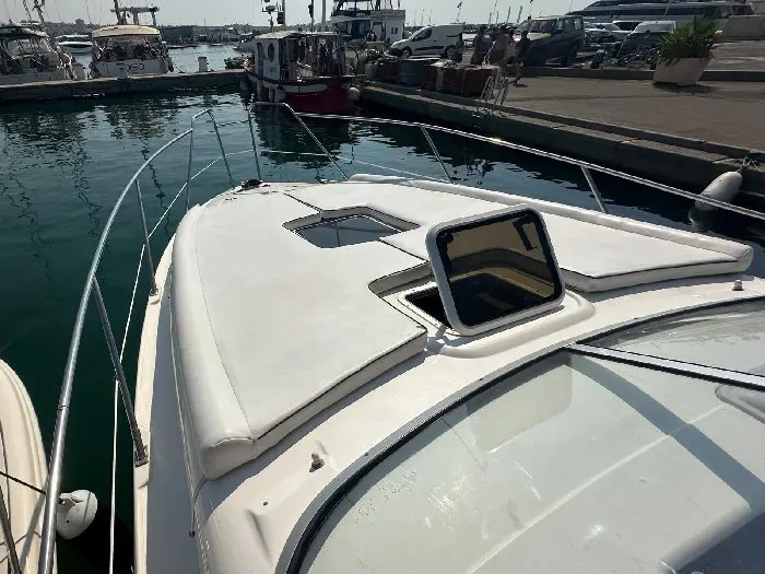 Sealine Bolero 28 — Vue rapprochée du pont avant et du pare-brise d’un bateau amarré au port.