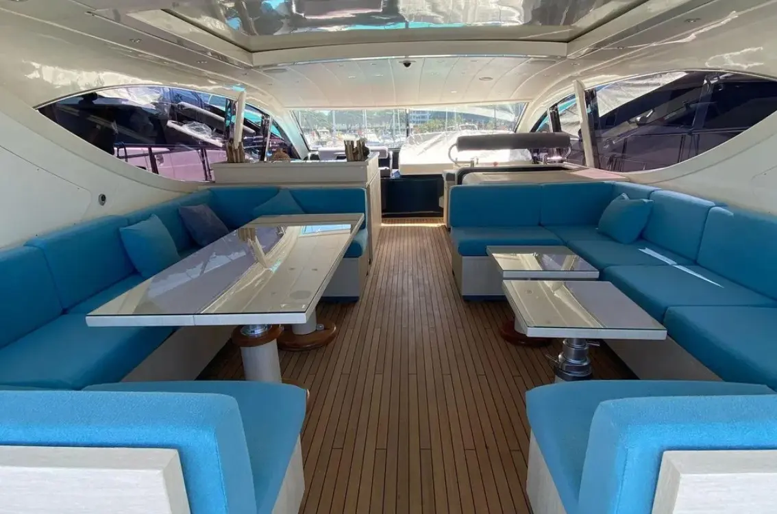 Leopard 24 — Salon intérieur avec banquettes bleues, tables et plancher en teck.