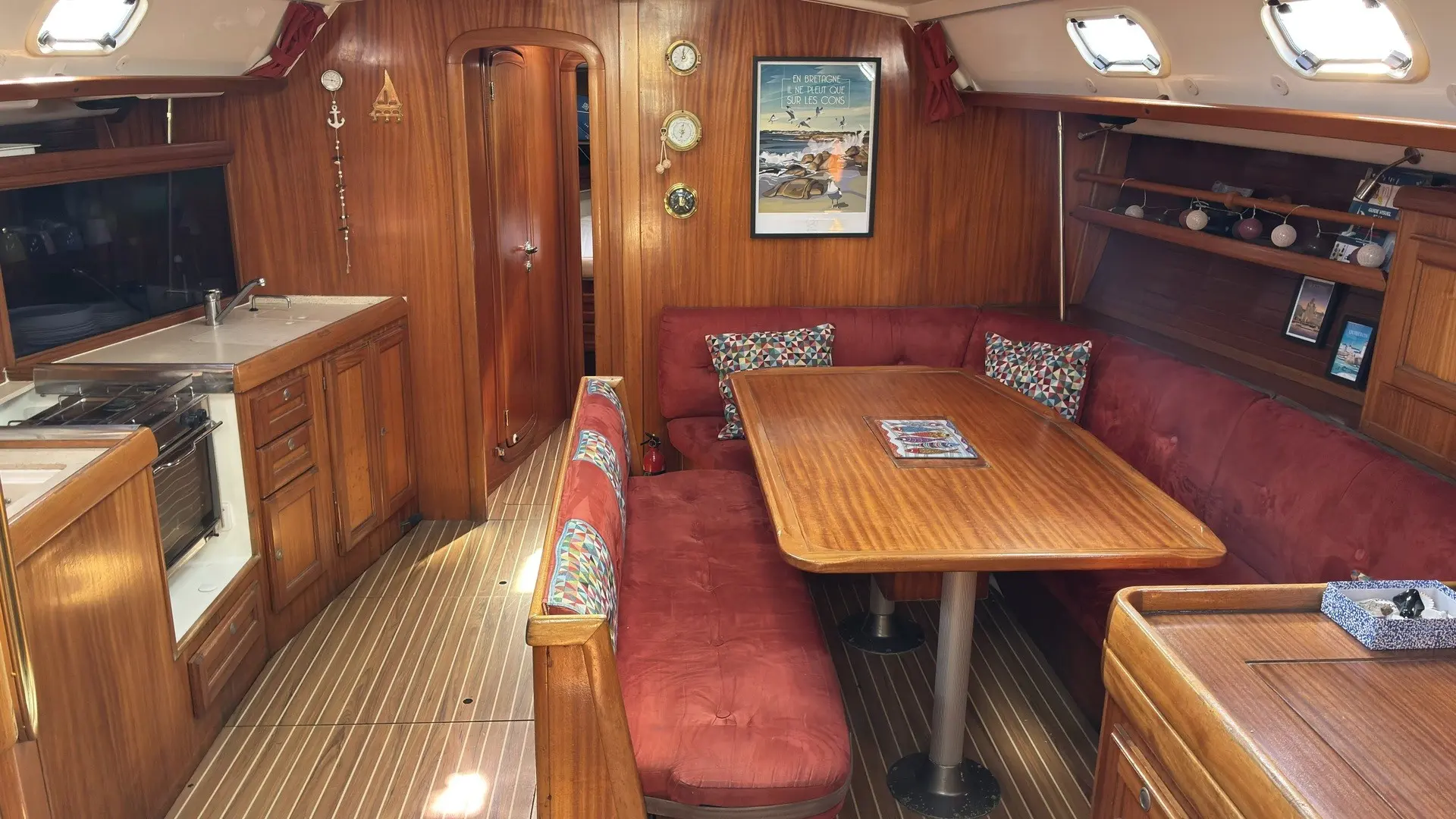 Dufour 43 — Vue intérieure du carré, avec banquettes, table et coin cuisine.