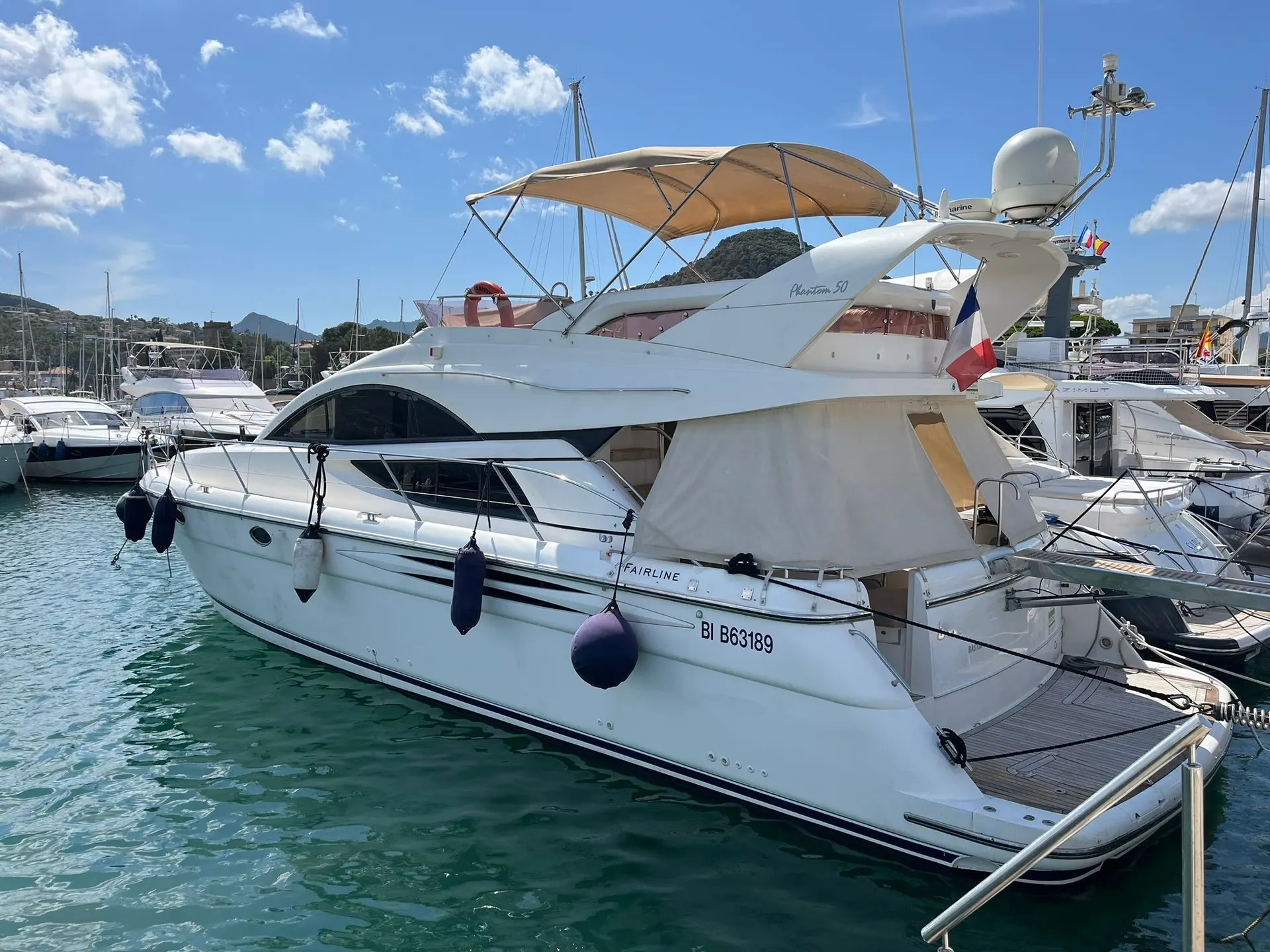 Fairline Phantom 50 — Vedette Fairline blanche photographiée de trois quarts arrière dans une marina.