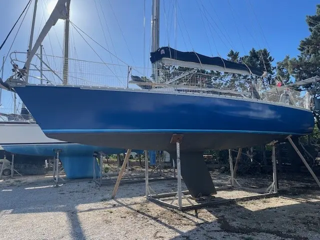 Jeanneau Selection 37 — Voilier bleu à mât posé sur bers dans un chantier nautique.