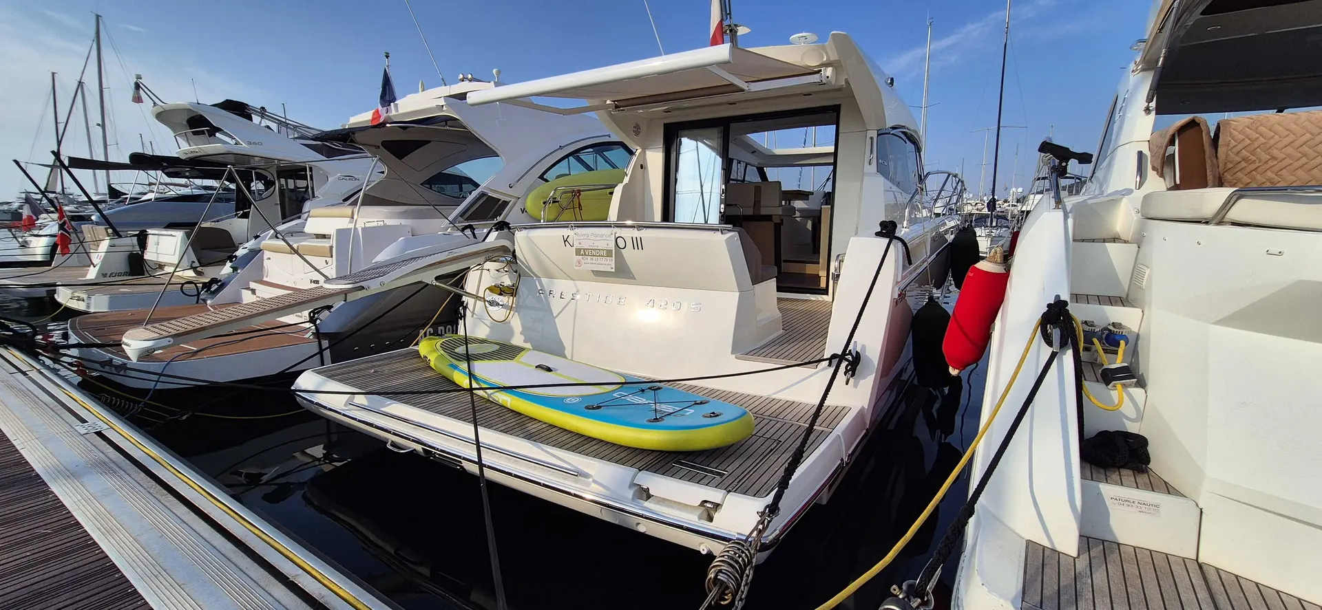 Prestige Yachts 420 S — Bateau à moteur blanc vu de trois quarts arrière, amarré dans un port.